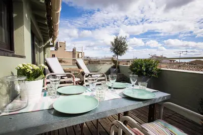 a table with plates and glasses on a balcony at Maison 1888 Carcassonne - Roof Terrace & Cité Views in Carcassonne
