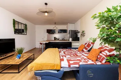 a living room with a bed and a kitchen at L'écrin Carcassonnais- parking gratuit- Terrasse in Carcassonne