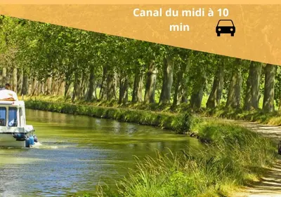 a boat traveling down a river with trees at L'écrin Carcassonnais- parking gratuit- Terrasse in Carcassonne