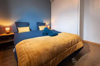 a bedroom with a large bed with a teddy bear on it at L'écrin Carcassonnais- parking gratuit- Terrasse in Carcassonne