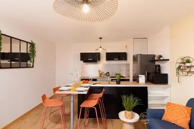 a kitchen and living room with a table and chairs at L'écrin Carcassonnais- parking gratuit- Terrasse in Carcassonne