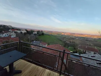 a balcony with a bench on a wooden deck at L'Escale du Puits in Puylaurens