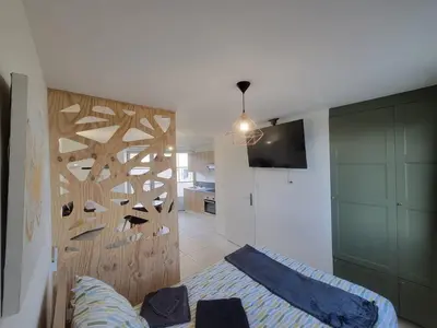 a bedroom with a bed and a wall with shoes on it at L'Escale du Puits in Puylaurens