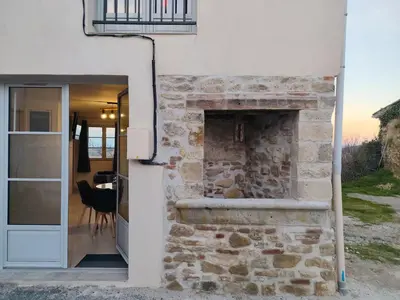 an open door to a stone fireplace in a house at L'Escale du Puits in Puylaurens