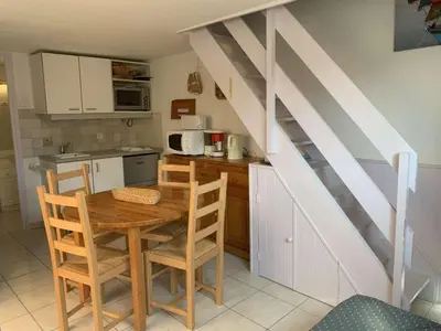 a kitchen with a wooden table and a staircase at AIG 56 – Pavillon T3 – Résidence Les Jardins d’Erato – Gruissan – 5 personnes in Gruissan