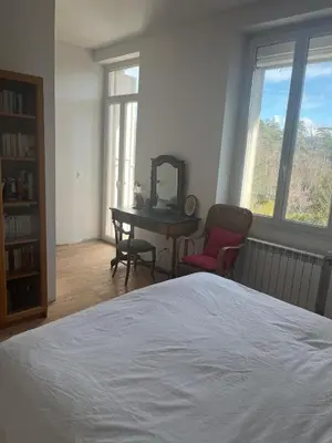 a bedroom with a bed and a desk with a mirror at Maison familiale face au lac de Saint-Ferréol in Revel