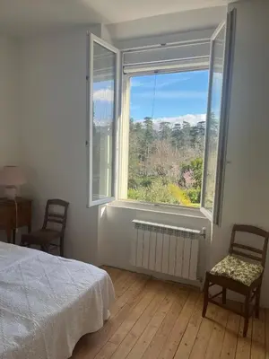 a bedroom with a bed and a large window at Maison familiale face au lac de Saint-Ferréol in Revel