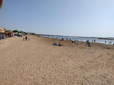 a group of people sitting on the beach at Villa confortable, parking, animaux OK - 6 pers. - FR-1-796-109 in Gruissan