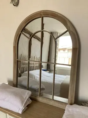 a bedroom with a bed and a mirror on the wall at Gîte de l'oiseau bleu in Lautrec