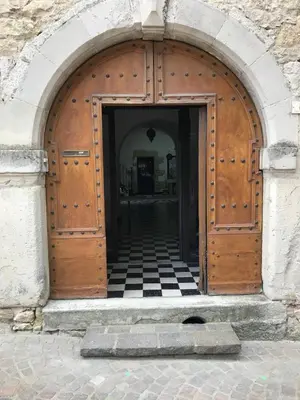 an open wooden door with a checkered floor at Gîte de l'oiseau bleu in Lautrec