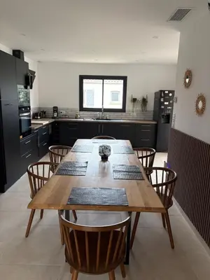 a large kitchen with a wooden table and chairs at Maison- Aude in Cuxac-dʼAude