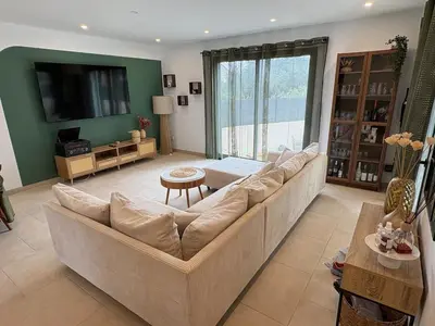 a kitchen with black cabinets and a table and a chair at Maison- Aude in Cuxac-dʼAude