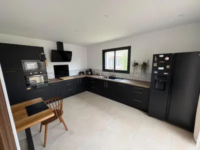 a wooden table and chairs in a kitchen at Maison- Aude in Cuxac-dʼAude