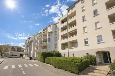 a dining room and living room with a table and chairs at Vue cité in Carcassonne