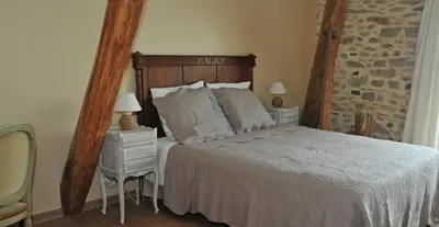 a bedroom with a large bed and two night stands at Maison Matisse in Saint-Nazaire-dʼAude