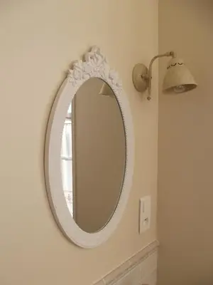 a white mirror on a wall next to a lamp at Maison Matisse in Saint-Nazaire-dʼAude