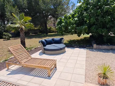 a bench and a couch sitting on a patio at Maison Matisse in Saint-Nazaire-dʼAude