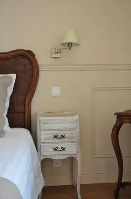 a bedroom with a bed with a dresser and a lamp at Maison Matisse in Saint-Nazaire-dʼAude