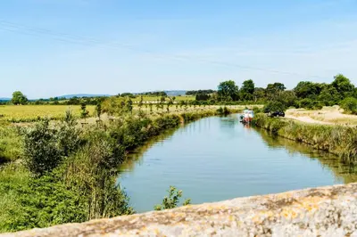 a river with a boat in the middle at Le Relais De Pigasse in Ouveillan