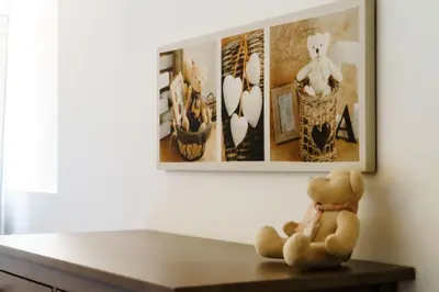 a teddy bear sitting on a table under a painting at Le Relais De Pigasse in Ouveillan