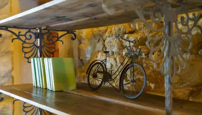a bike sitting on a shelf with a book at Le Relais De Pigasse in Ouveillan