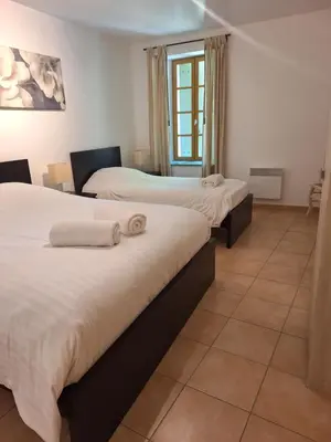a hotel room with two beds with towels on them at Le Relais De Pigasse in Ouveillan