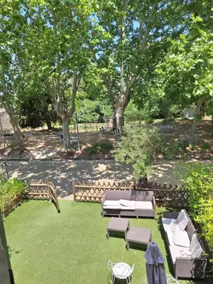 a garden with a table and benches and trees at Le Relais De Pigasse in Ouveillan