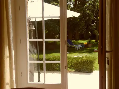 an open door to a yard with an umbrella at Gîte Belfloret in Renneville