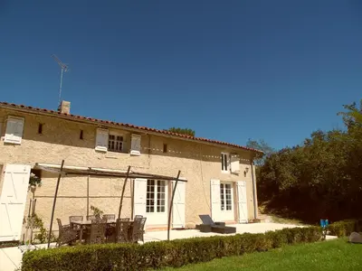 a house with two chairs and a table in front of it at Gîte Belfloret in Renneville