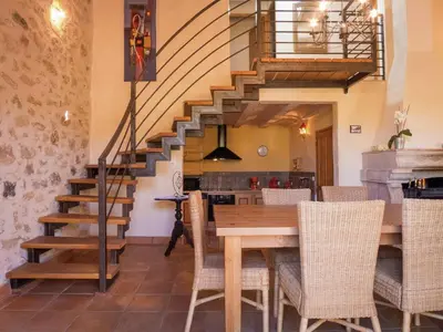 a dining room with a table and a staircase at Sunny Escape to Serenity in Fraissé-des-Corbières
