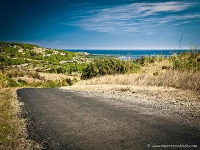 an empty road with the ocean in the background at Sunny Escape to Serenity in Fraissé-des-Corbières