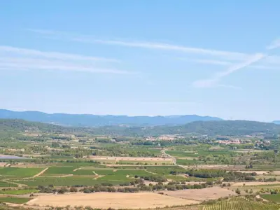 an aerial view of a cultivated field with mountains in the background at Sunny Escape to Serenity in Fraissé-des-Corbières