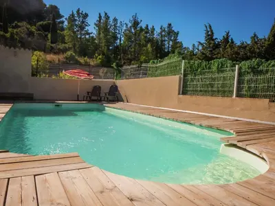 a swimming pool with a wooden floor and a wooden deck at Sunny Escape to Serenity in Fraissé-des-Corbières