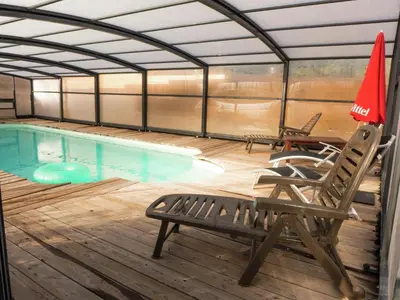a swimming pool with two chairs and a umbrella at Sunny Escape to Serenity in Fraissé-des-Corbières