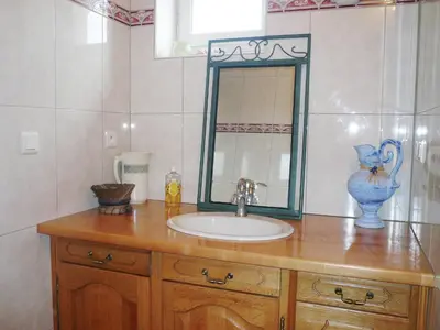 a bathroom sink with a mirror and a blue vase at Villa in Conilhac with Private Terrace in La Serpent