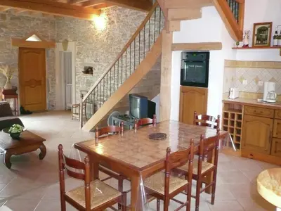 a kitchen and dining room with a wooden table and chairs at Villa in Conilhac with Private Terrace in La Serpent