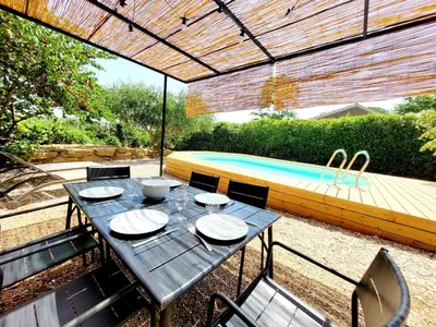 a patio with a table and chairs and a swimming pool at Village House in La Caunette with Pool in La Caunette
