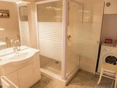 a bathroom with a shower and a sink and a washing machine at Village House in La Caunette with Pool in La Caunette
