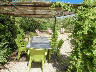 a wooden table and chairs under a pergola at Village House in La Caunette with Pool in La Caunette