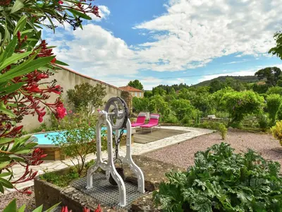 a garden with two pink chairs and a pool at Holiday Home in Félines-Minervois with Pool in Félines-Minervois