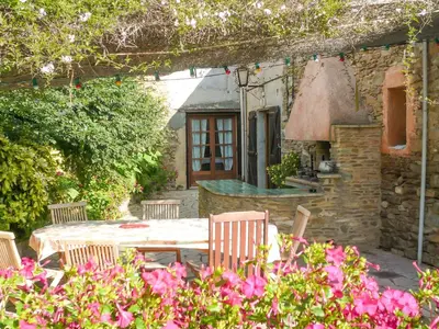 a table and chairs in a garden with flowers at Holiday Home in Félines-Minervois with Pool in Félines-Minervois