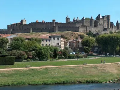 a castle sitting on top of a hill next to a river at Holiday Home in Félines-Minervois with Pool in Félines-Minervois