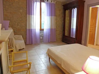 a bedroom with a bed and a table and window at Holiday Home in Montbrun with Pool & Vineyards in Montbrun-des-Corbières