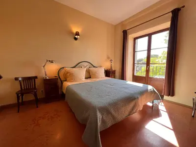 a bedroom with a large bed and a window at Vinauberge in Poilhès