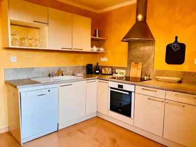 a kitchen with white cabinets and a sink at Vinauberge in Poilhès