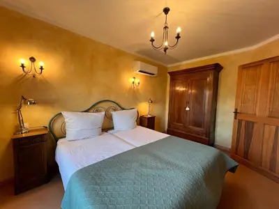 a bedroom with a large bed with a blue blanket at Vinauberge in Poilhès