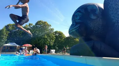 a young man jumping into a swimming pool at Camping Le Pré Cathare in Lavelanet