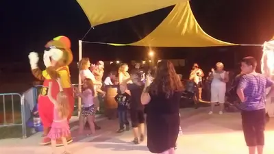 a group of people standing on a stage with mascots at Camping Le Pré Cathare in Lavelanet