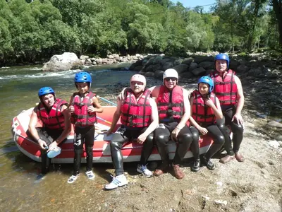 a group of people posing next to a raft on a river at Camping Le Pré Cathare in Lavelanet