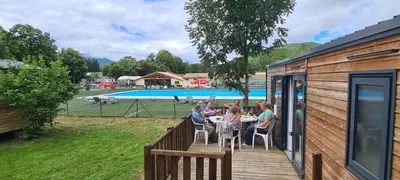 a group of people sitting at a table on a deck at Camping Le Pré Cathare in Lavelanet